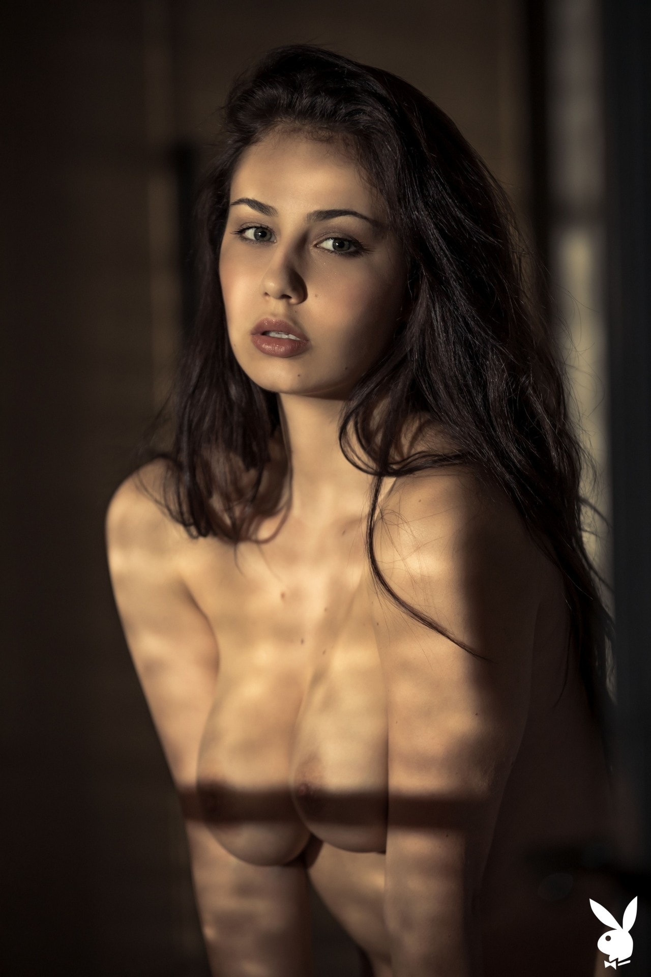 Busty all natural brunette Sophie Limma undressing in a dim room